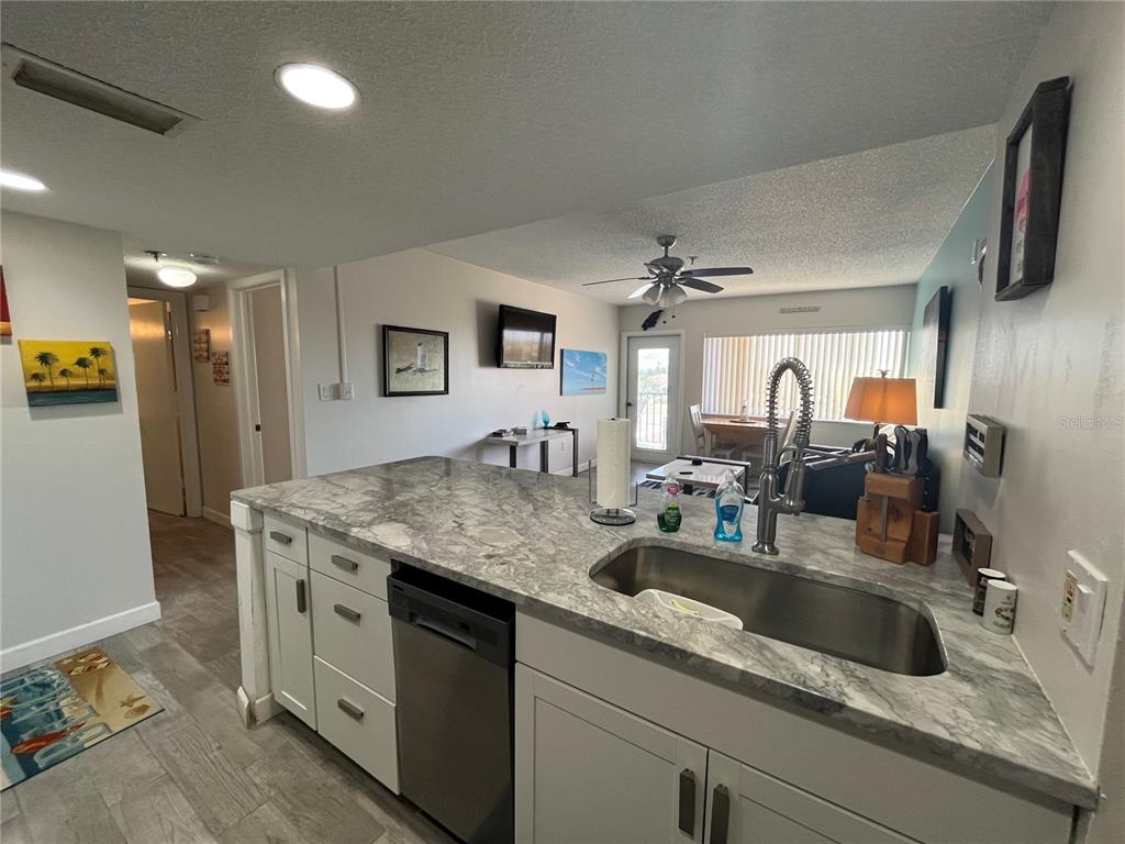 3160 Matecumbe Key Road, Unit 235 Punta Gorda, FL 33955 - Photo 4 of 15 a kitchen with stainless steel appliances granite countertop a sink and a refrigerator