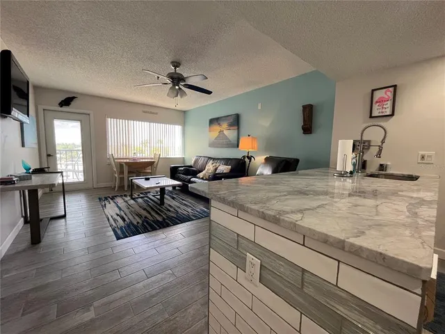 a view of a kitchen counter top space with furniture wooden floor and windows