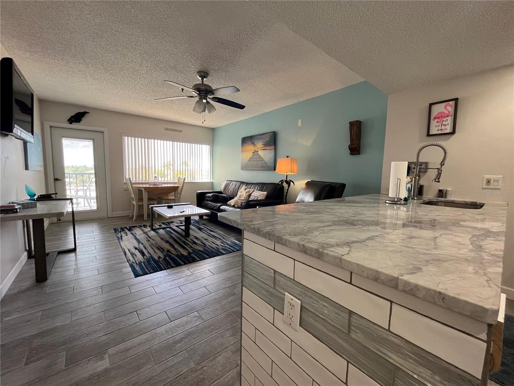 3160 Matecumbe Key Road, Unit 235 Punta Gorda, FL 33955 - Photo 5 of 15 a view of a kitchen counter top space with furniture wooden floor and windows