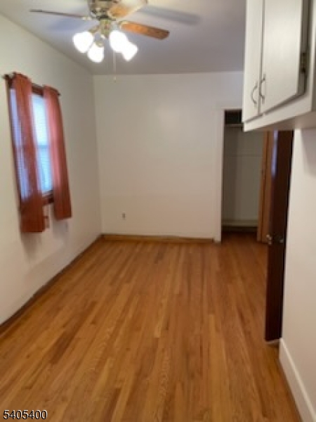 72 Baldwin Place, Unit 2 Bloomfield, NJ 07003 - Photo 7 of 9 a view of an empty room with wooden floor and a chandelier