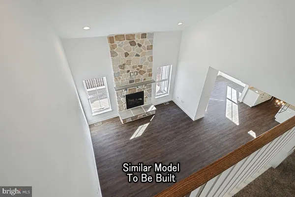 an entrance to room with wooden floor and a fireplace