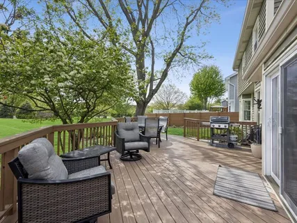 a view of a patio with couches chairs and wooden floor
