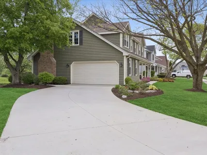 a front view of a house with a garden and trees
