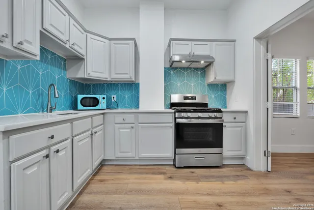 a kitchen with white cabinets and appliances