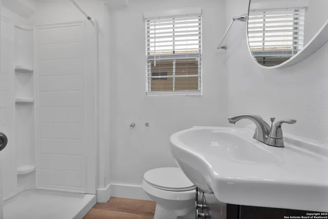 a bathroom with a sink a toilet and a mirror