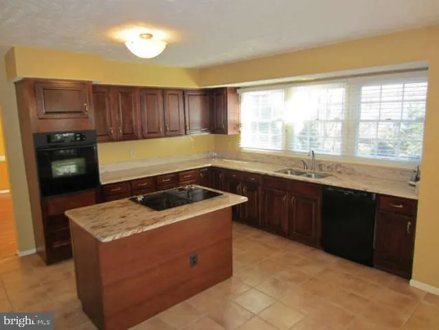 a kitchen with a stove sink and cabinets