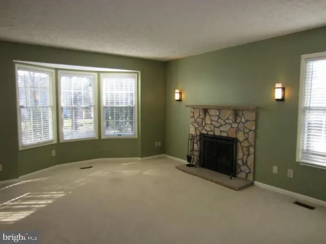 a spacious bedroom with a fireplace and a window