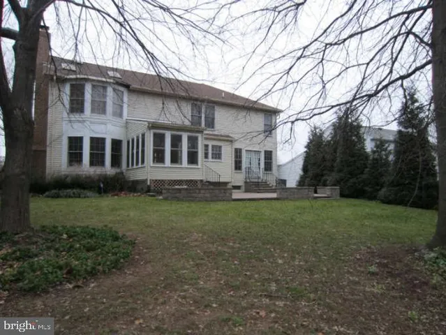 a view of a yard in front of a house with large trees