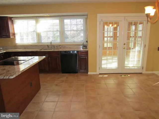 a kitchen with granite countertop a sink and a stove next to a window