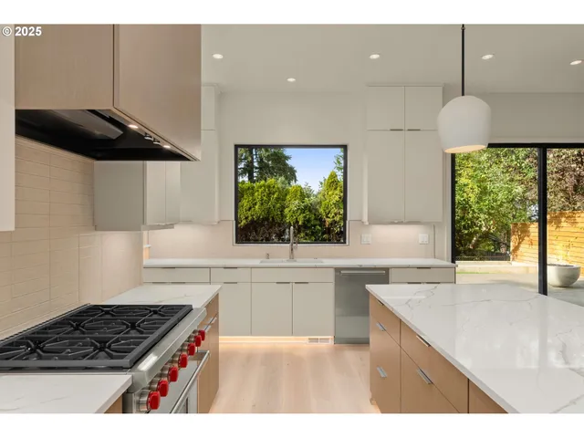 a kitchen with stainless steel appliances a sink a stove and a wooden cabinets