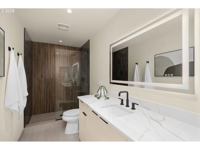 a bathroom with a sink vanity toilet and shower