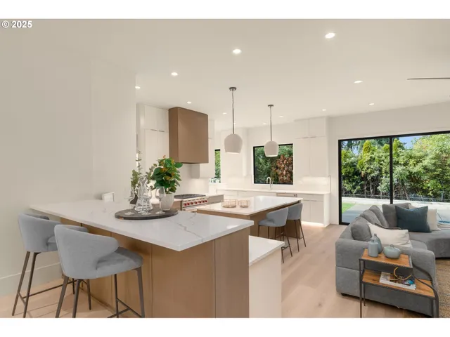 a dining room with kitchen island stainless steel appliances kitchen island granite countertop furniture and a large window