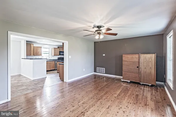 an empty room with windows and a ceiling fan