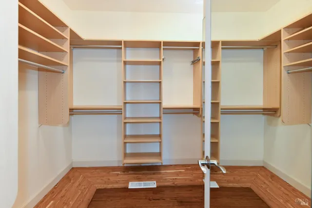 a view of walk in closet with empty racks