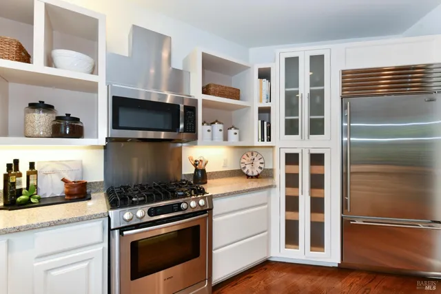 a kitchen with stainless steel appliances granite countertop a stove and a microwave
