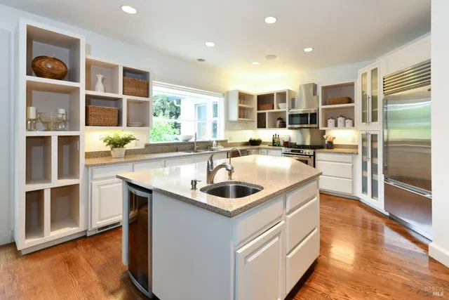 a kitchen with stainless steel appliances granite countertop a sink and stove