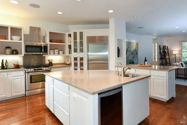 a kitchen with stainless steel appliances granite countertop a sink and a stove top oven