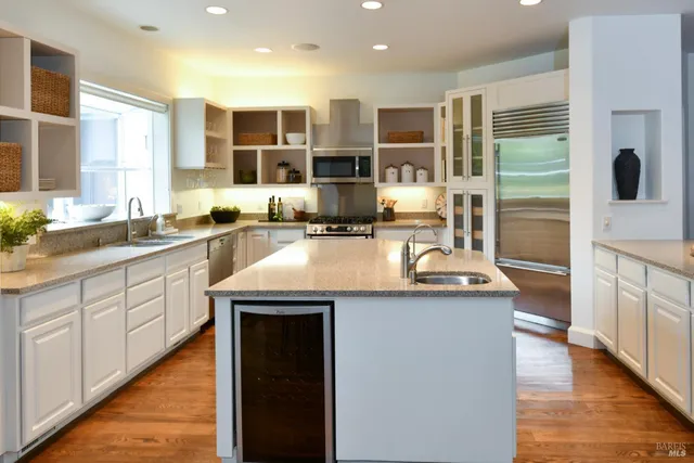 a kitchen with stainless steel appliances kitchen island granite countertop a sink and cabinets