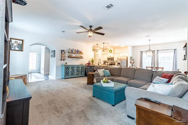 a living room with furniture and a ceiling fan
