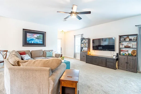 a living room with furniture a ceiling fan and a window