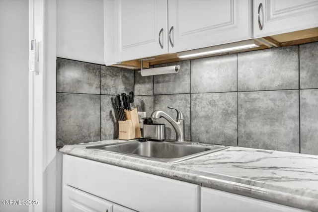 a bedroom with a bed and a flat tv screen on the dresser