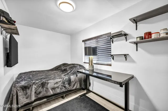 a bedroom with a bed and a flat tv screen on a dresser