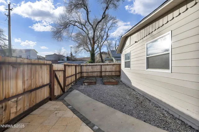 a view of a pathway of a house with wooden fence