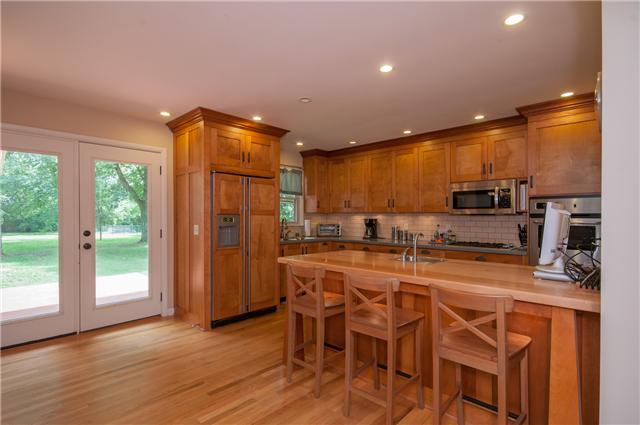 350 Stable Road Franklin, TN 37069 - Photo 4 of 18 Impressive Arts & Crafts Kitchen features custom shaker cabinets, solid surface counters,subway backsplash, gas cooktop, double ovens, and a butcher block bar w/ stools & bar sink.