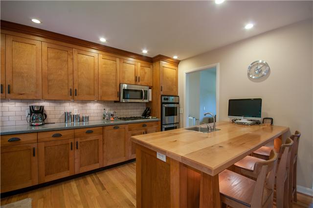 350 Stable Road Franklin, TN 37069 - Photo 6 of 18 Impressive Arts & Crafts Kitchen features custom shaker cabinets, solid surface counters,subway backsplash, gas cooktop, double ovens, and a butcher block bar w/ stools & bar sink.