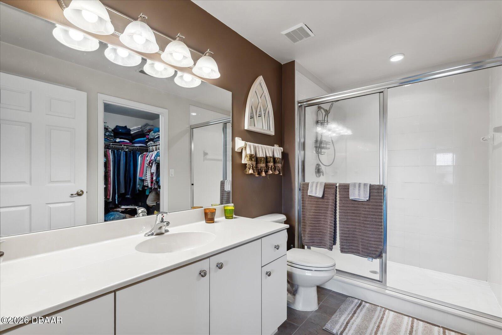3617 Romea Circle New Smyrna Beach, FL 32168 - Photo 17 of 28 a bathroom with a toilet a sink a shower a mirror and vanity