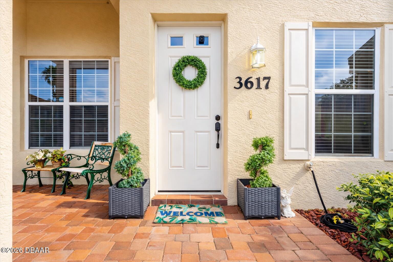 3617 Romea Circle New Smyrna Beach, FL 32168 - Photo 3 of 28 a view of a entryway door of the house with potted plants