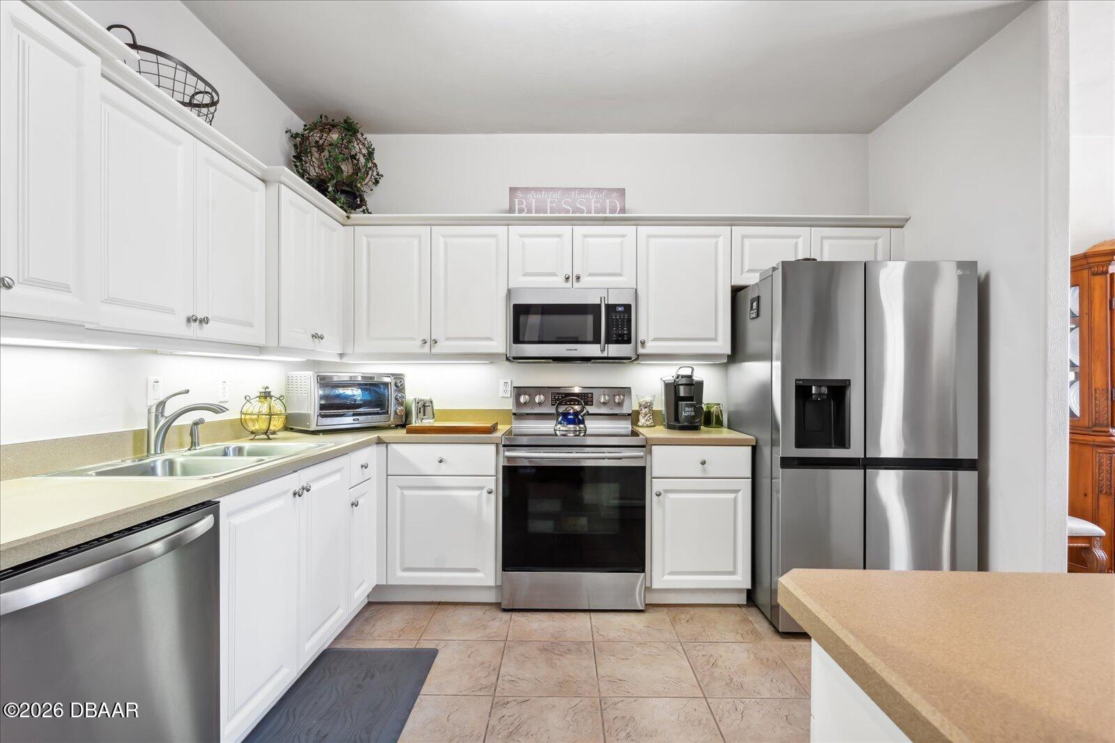 3617 Romea Circle New Smyrna Beach, FL 32168 - Photo 9 of 28 a kitchen with a sink a microwave and refrigerator