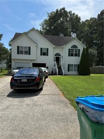 a car parked in front of a house with a yard