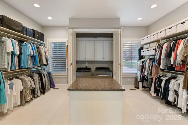 a view of walk in closet with clothes and shoes
