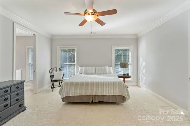 a bedroom with a bed a chandelier and a dresser