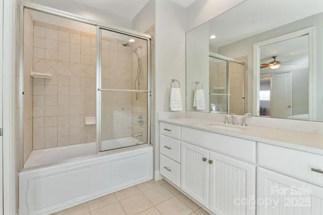 a bathroom with a double vanity sink and mirror with bathtub