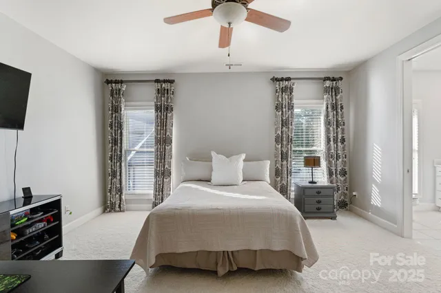 a bedroom with a bed and a flat tv screen on dresser