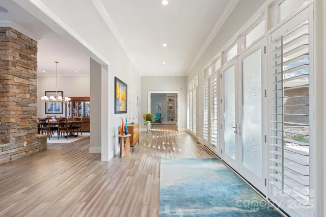 a view of a hallway with wooden floor and furniture