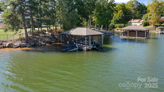 a view of a lake with a table and chairs under an umbrella