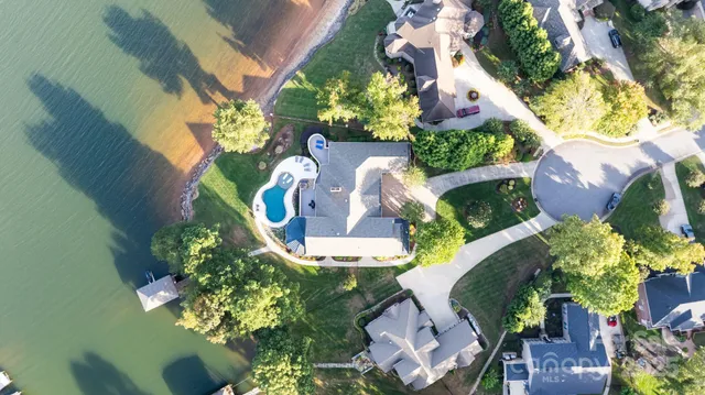 an aerial view of a house with a yard and a large tree