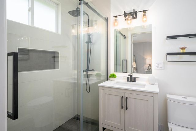 a bathroom with a sink a toilet a mirror and vanity