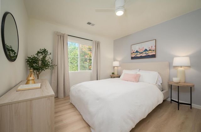 a bedroom with a large bed and a potted plant
