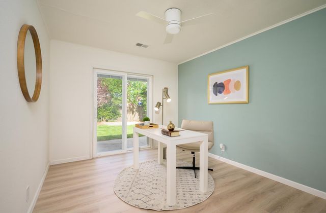 a dining room with wooden floor and a floor to ceiling window