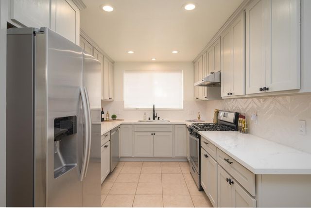 a kitchen with a sink a refrigerator and cabinets