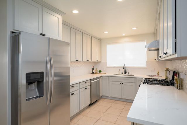a kitchen with stainless steel appliances granite countertop a refrigerator and a sink