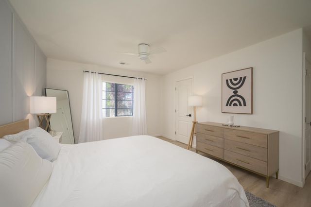 a bedroom with a bed and a lamp on dresser