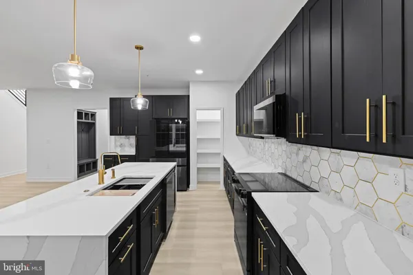 a kitchen with stainless steel appliances kitchen island granite countertop a sink a stove and a wooden cabinets