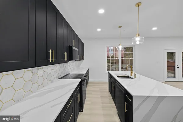 a kitchen with stainless steel appliances kitchen island granite countertop a sink a stove and a wooden floors