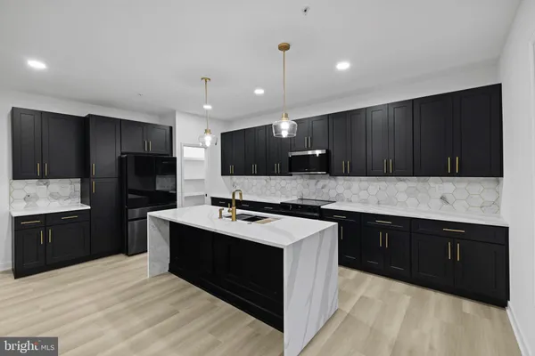 a kitchen with a sink a stove a refrigerator and cabinets