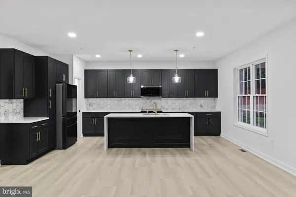 a kitchen with kitchen island a sink stainless steel appliances and refrigerator